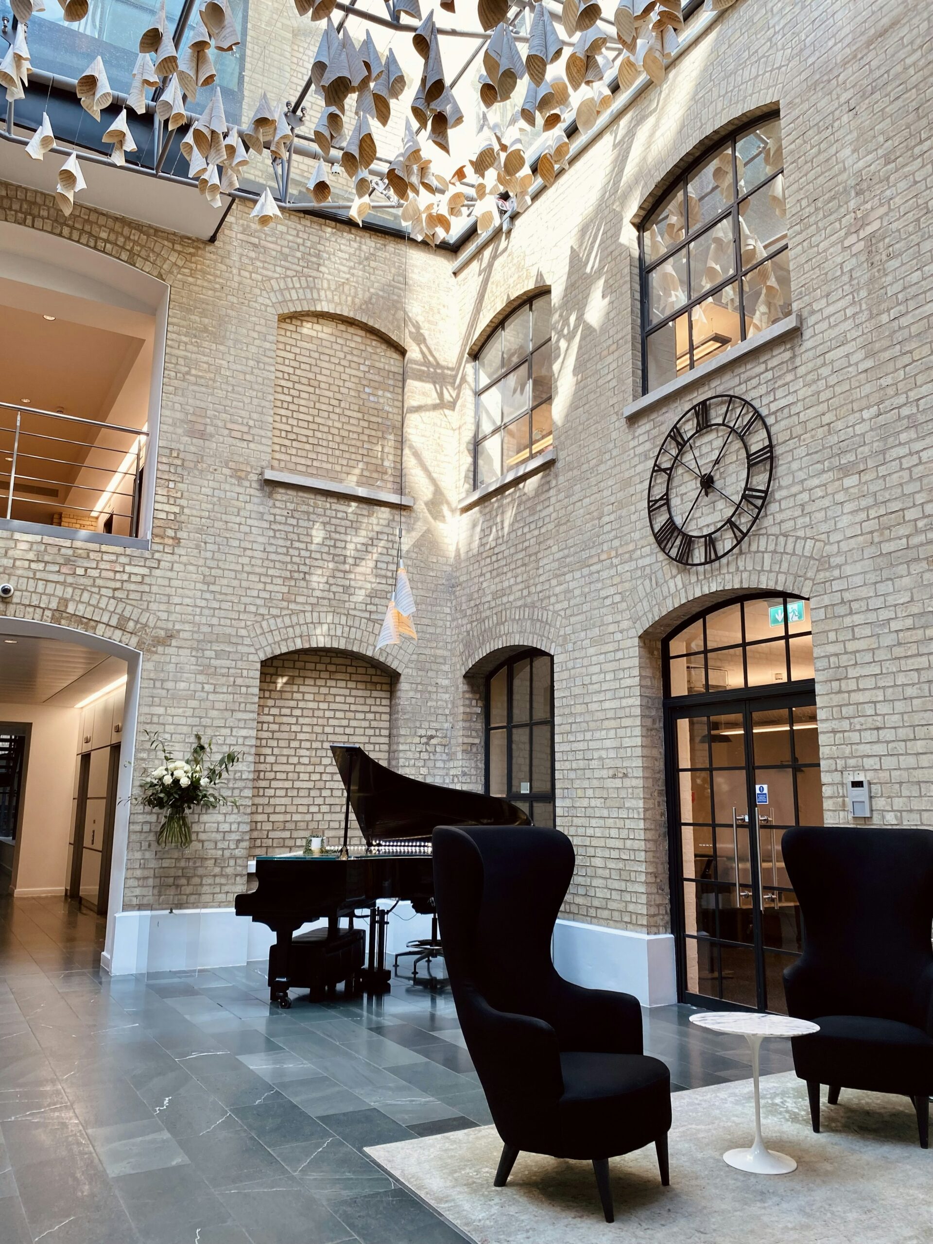 une grande salle avec un piano et une horloge au mur